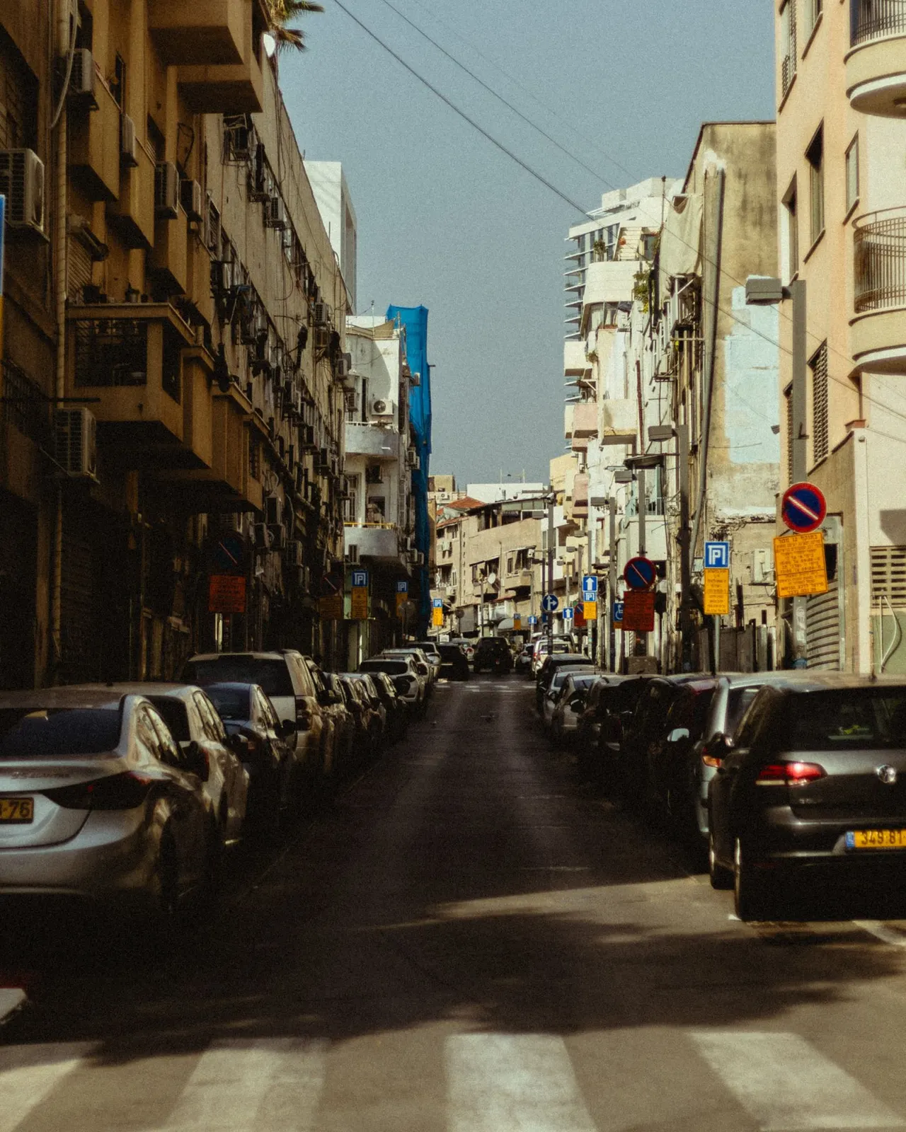 רחוב עירוני עם בנייני מגורים ומכוניות חונות